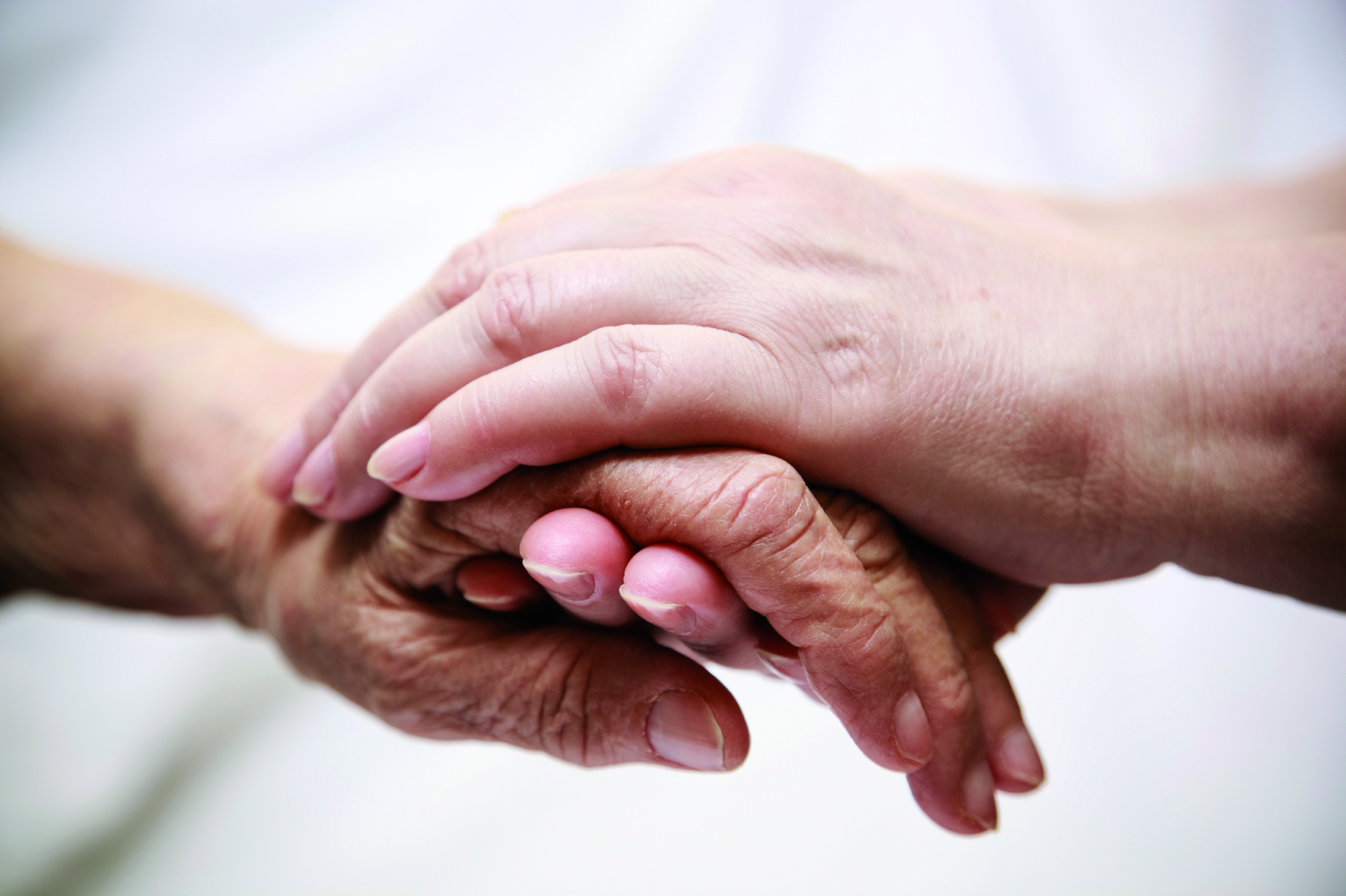 adult helping senior in hospital